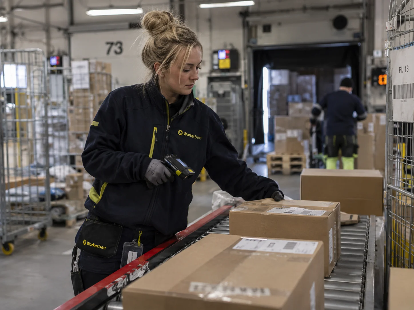 Lagerarbetare skannar ett paket vid en transportbana.